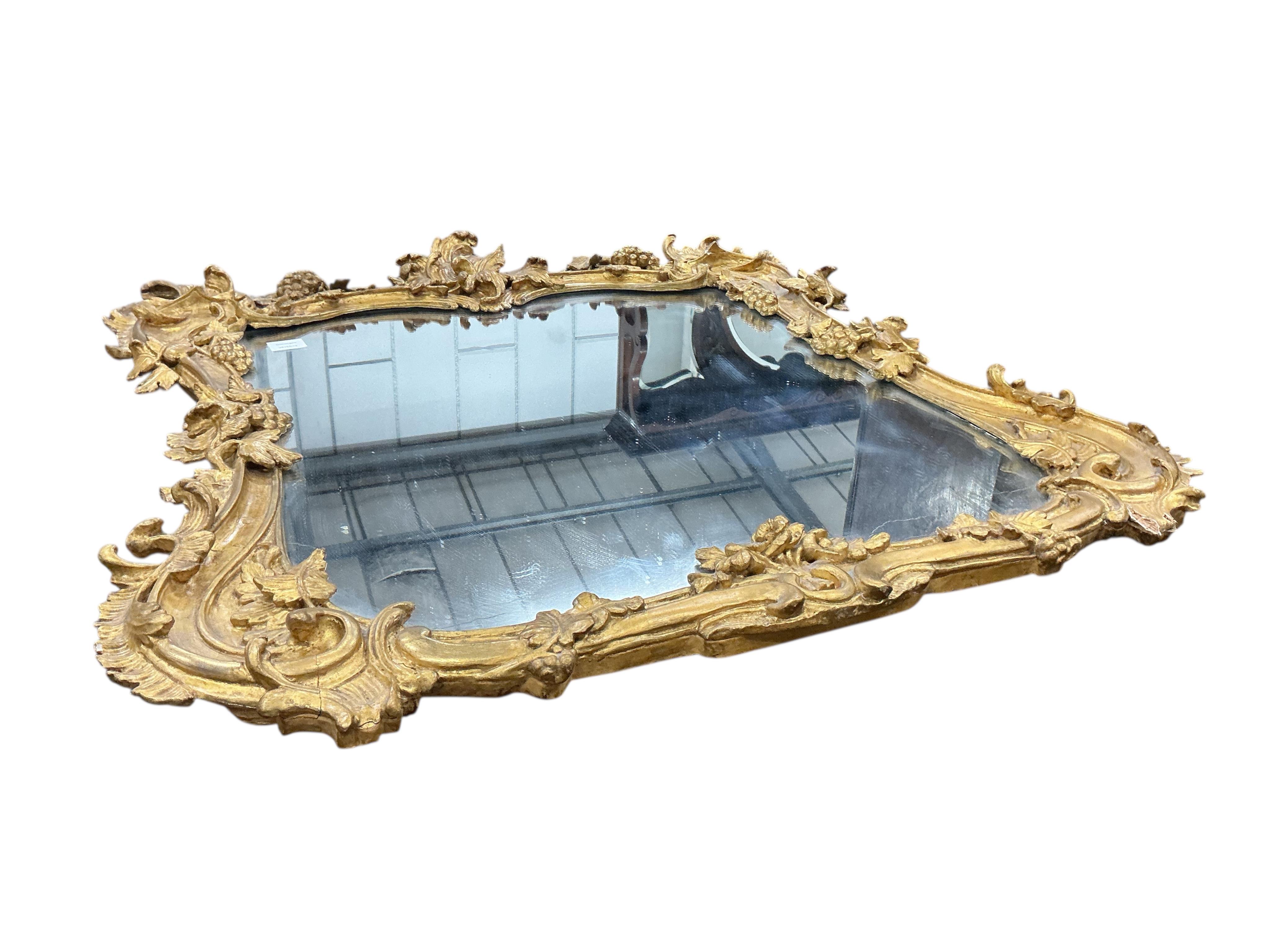 A Victorian carved giltwood and composition wall mirror with fruiting vine borders, width 98cm, height 104cm